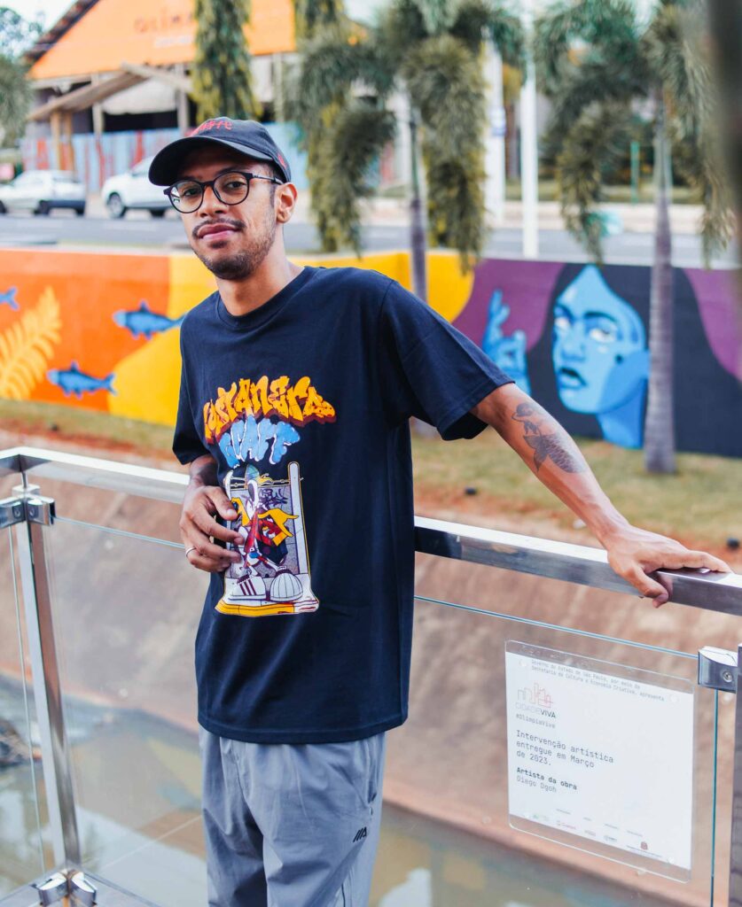 Diego DGOH em frente ao mural de Olímpia